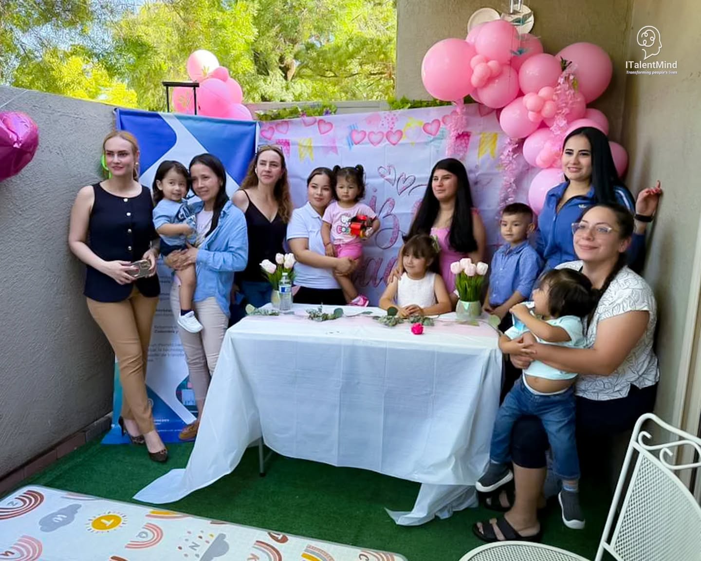 Mujeres, niños y niñas comparten una celebración junto al emblema de ITalentMind.