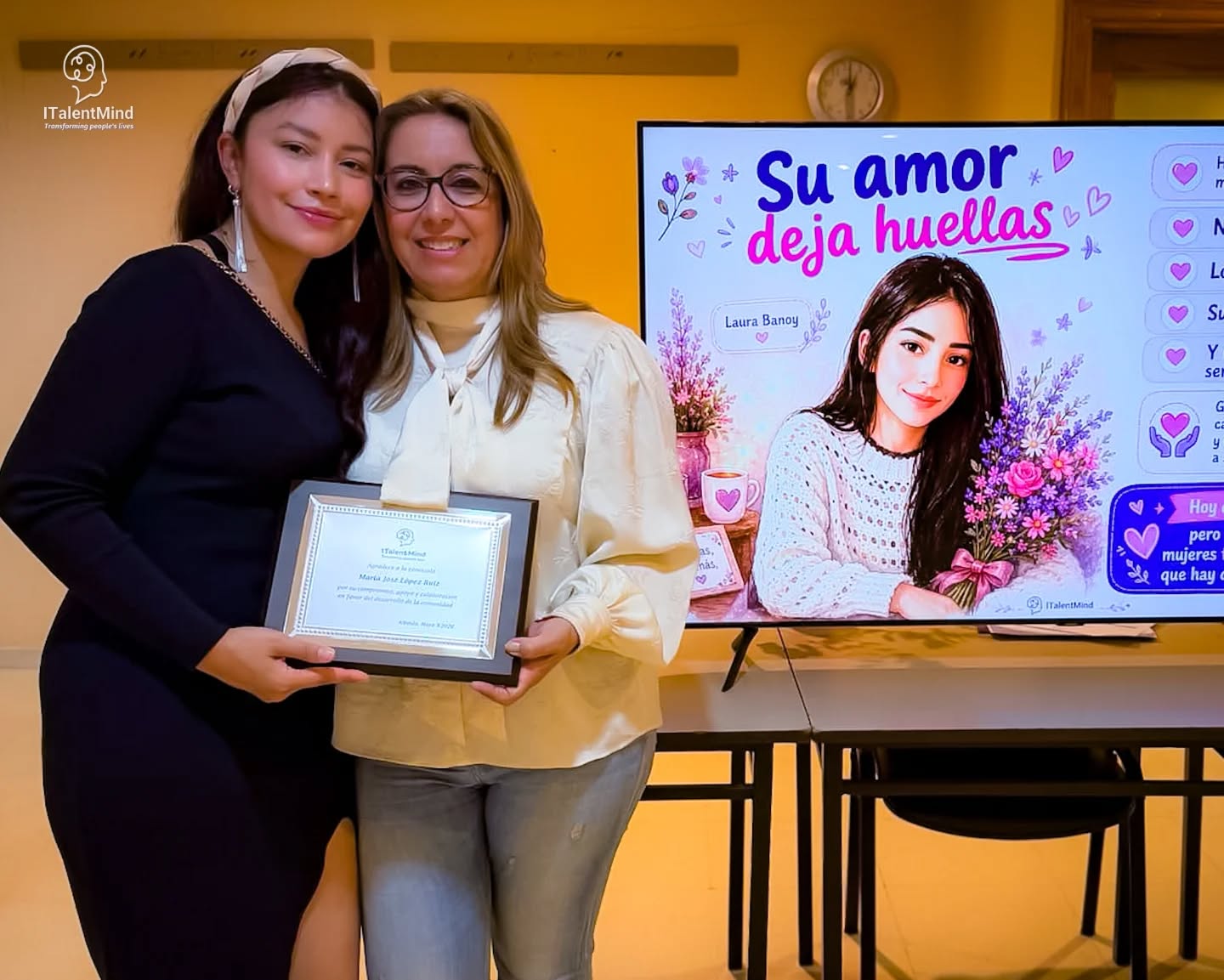 Dos mujeres sostienen un reconocimiento durante un encuentro de ITalentMind.