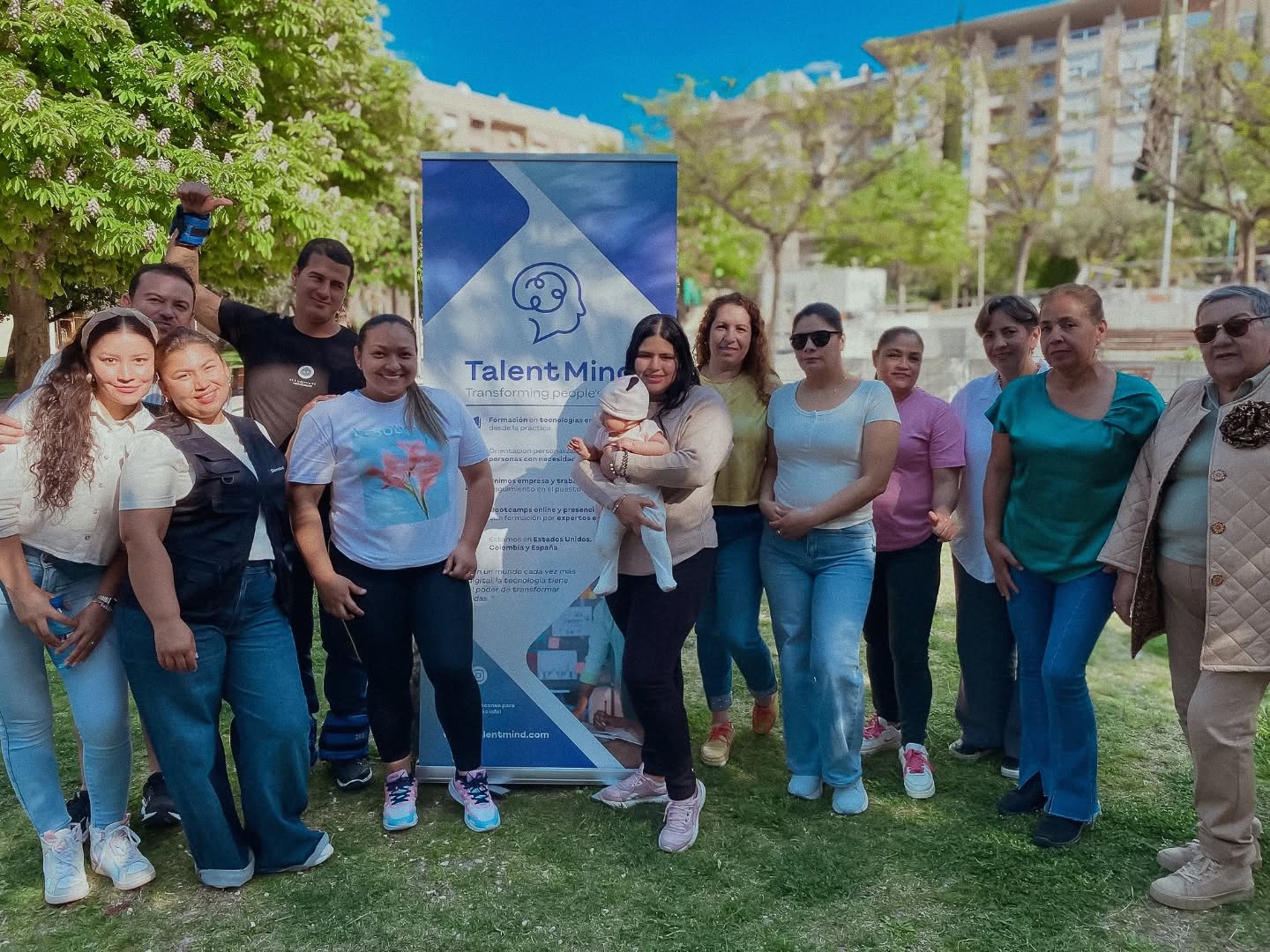 Un grupo de participantes se reúne en un parque junto al emblema de ITalentMind.