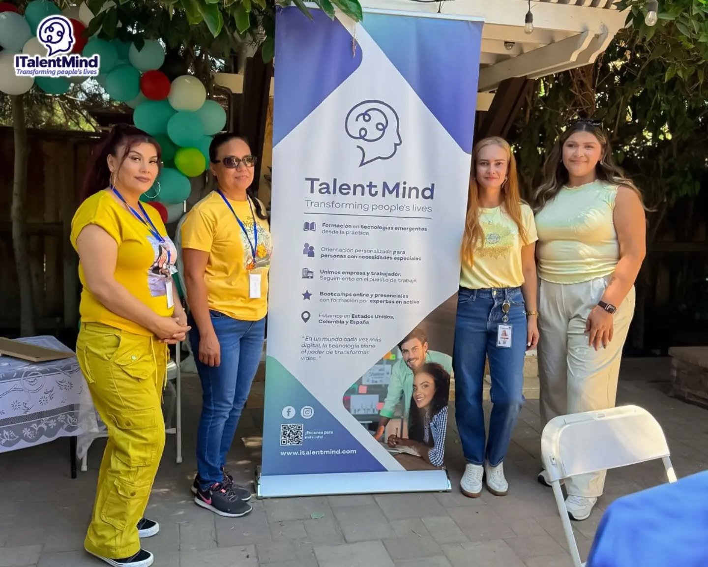 Cuatro participantes comparten un encuentro al aire libre junto a un pendón de ITalentMind.